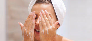 Mujer realizándose una limpieza facial profunda en casa 